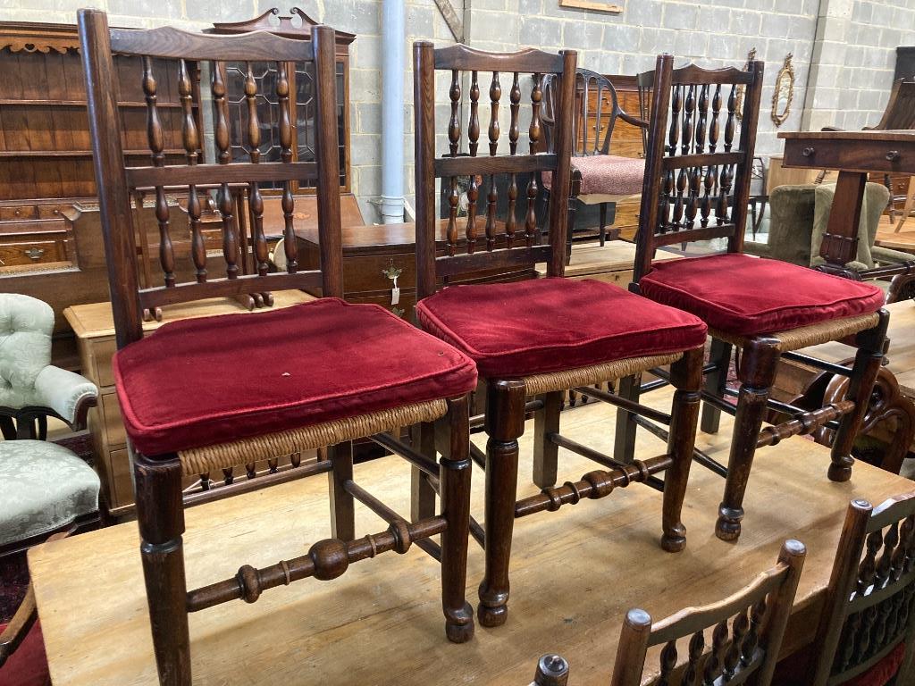 A harlequin set of eleven 19th century ash spindle back rush seat chairs